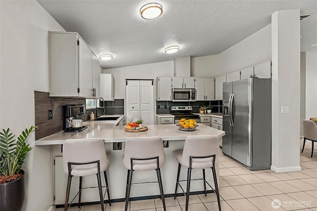 1027 Fishpond Rd, Kelso, WA 98626 - kitchen with stainless steel appliances, a sink, a peninsula, light countertops, and tasteful backsplash