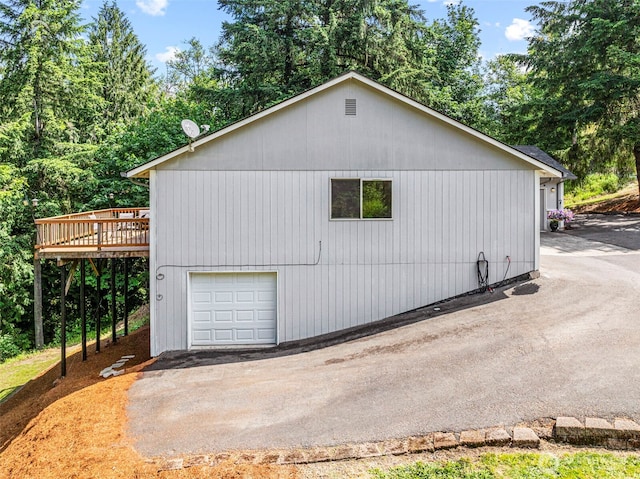 1027 Fishpond Rd, Kelso, WA 98626 - view of side of property with a wooden deck, a garage, and view of scattered trees