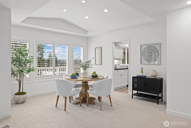 dining room with a raised ceiling, baseboards, light carpet, and recessed lighting