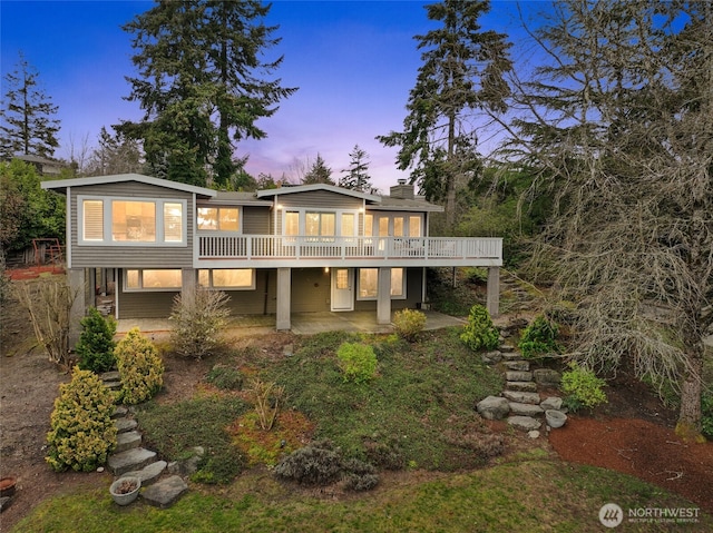 back of property featuring a patio, a wooden deck, and a chimney