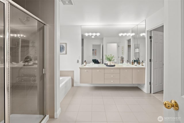 full bath featuring tile patterned flooring, double vanity, baseboards, a garden tub, and a stall shower