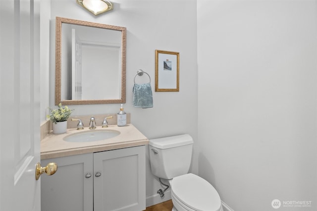 half bath featuring vanity and toilet
