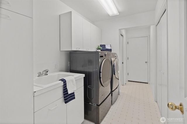 laundry room featuring independent washer and dryer, a sink, and cabinet space