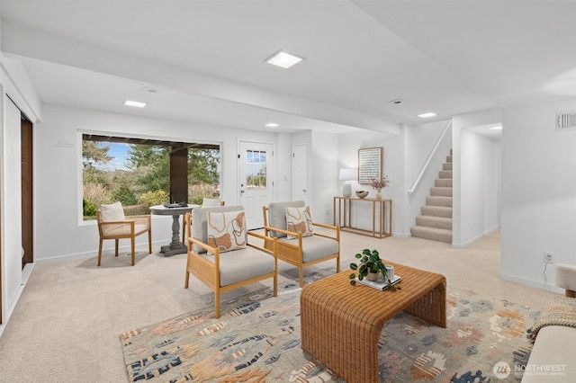 living room with visible vents, baseboards, light carpet, and stairway