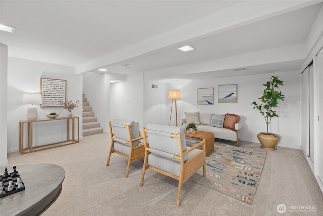 carpeted living room featuring baseboards and stairway