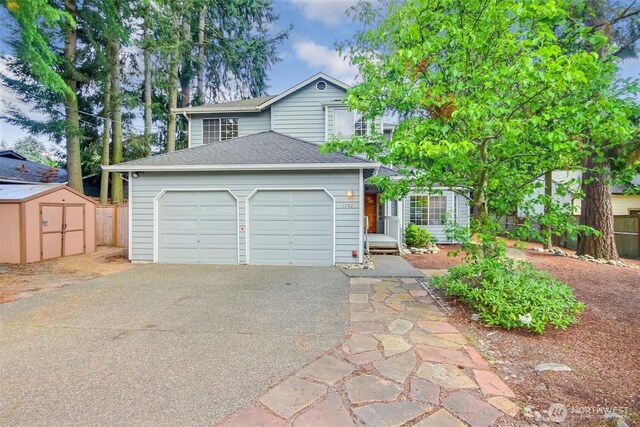 1742 N 122nd St, Seattle, WA 98133 - view of front of home featuring asphalt driveway, a garage, a shed, roof with shingles, and fence