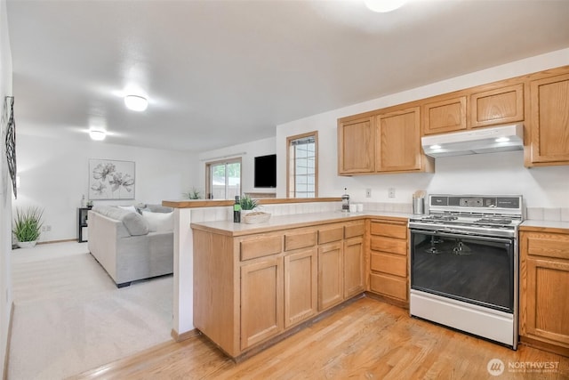 1742 N 122nd St, Seattle, WA 98133 - kitchen featuring electric range, under cabinet range hood, a peninsula, open floor plan, and light countertops