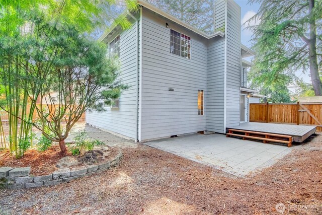 1742 N 122nd St, Seattle, WA 98133 - rear view of property with a patio, a chimney, a wooden deck, and fence