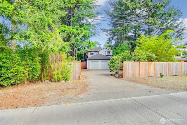 1742 N 122nd St, Seattle, WA 98133 - view of property hidden behind natural elements featuring fence, driveway, and a garage