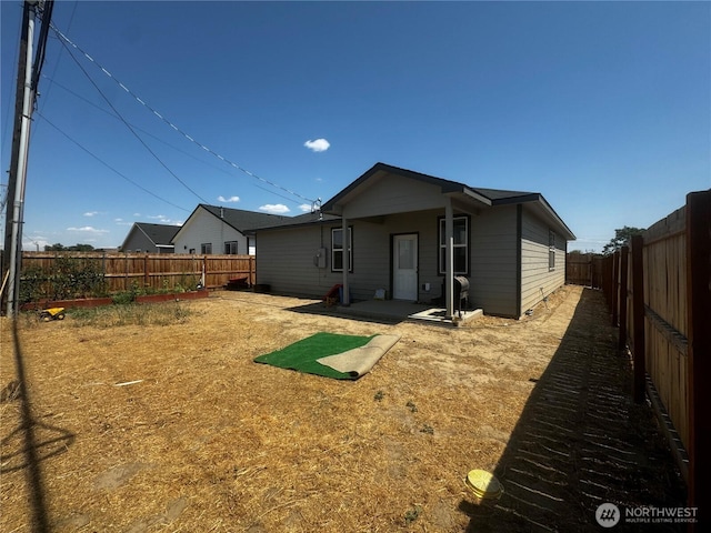 rear view of property featuring a fenced backyard and a patio