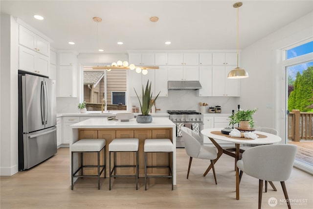 24858 NE 1st Pl, Sammamish, WA 98074 - kitchen with stainless steel appliances, under cabinet range hood, a sink, white cabinetry, and recessed lighting