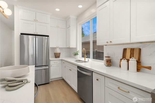 24858 NE 1st Pl, Sammamish, WA 98074 - kitchen featuring appliances with stainless steel finishes, a sink, light wood-style flooring, white cabinetry, and recessed lighting