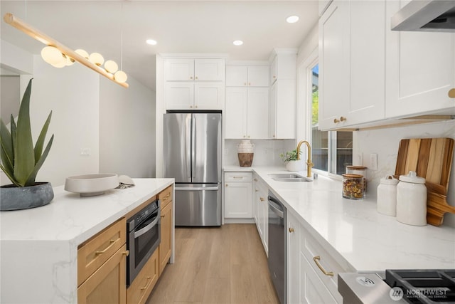 24858 NE 1st Pl, Sammamish, WA 98074 - kitchen featuring stainless steel appliances, a sink, wall chimney exhaust hood, light wood-type flooring, and white cabinets