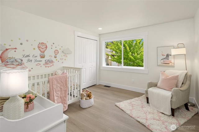 24858 NE 1st Pl, Sammamish, WA 98074 - bedroom featuring wood finished floors, a closet, baseboards, a nursery area, and recessed lighting