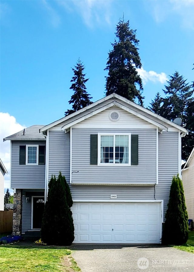 view of front facade with an attached garage, driveway, and a front lawn