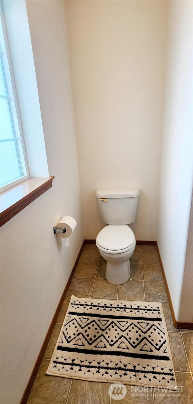 bathroom featuring baseboards and toilet