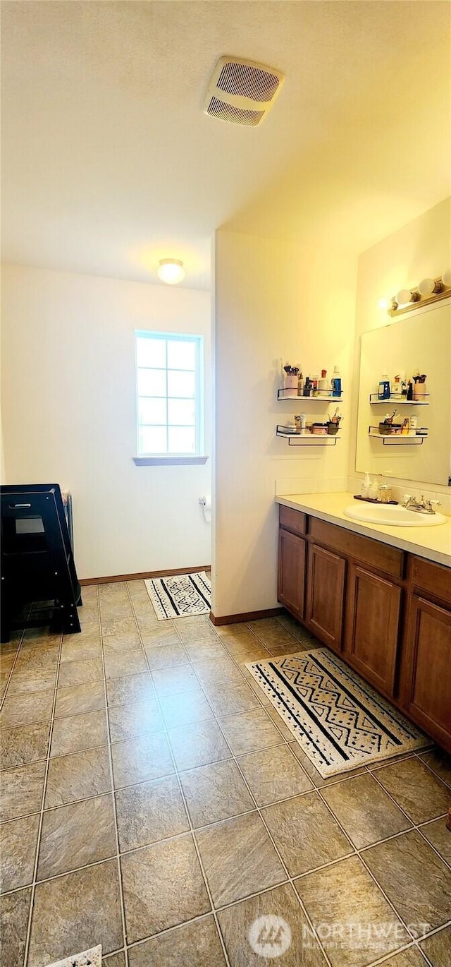 bathroom with baseboards, visible vents, and vanity