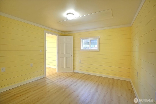 566 Sundin Dr, Camano Island, WA 98282 - empty room with baseboards, wooden walls, crown molding, and light wood-type flooring