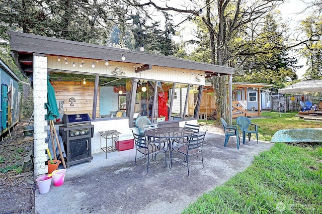 view of patio featuring fence, a grill, and an outdoor structure