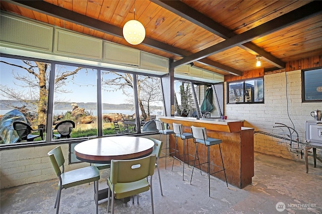 sunroom featuring a water view and beam ceiling