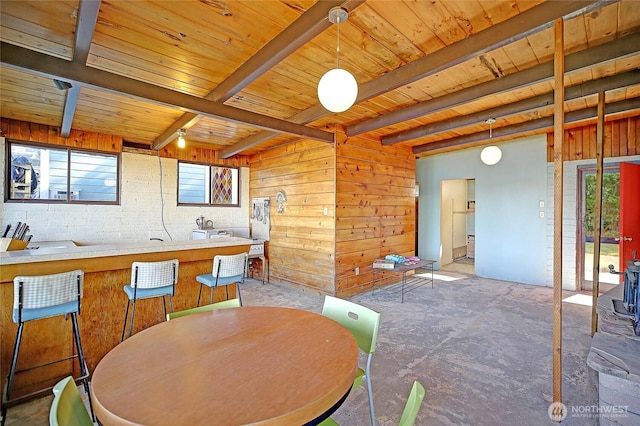 dining space featuring wood ceiling, beamed ceiling, and a wealth of natural light