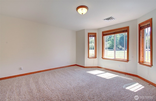 spare room featuring baseboards, carpet flooring, and visible vents
