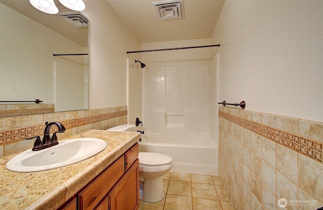 bathroom featuring toilet, tile walls, vanity, and visible vents