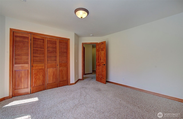 unfurnished bedroom featuring light colored carpet, a closet, and baseboards