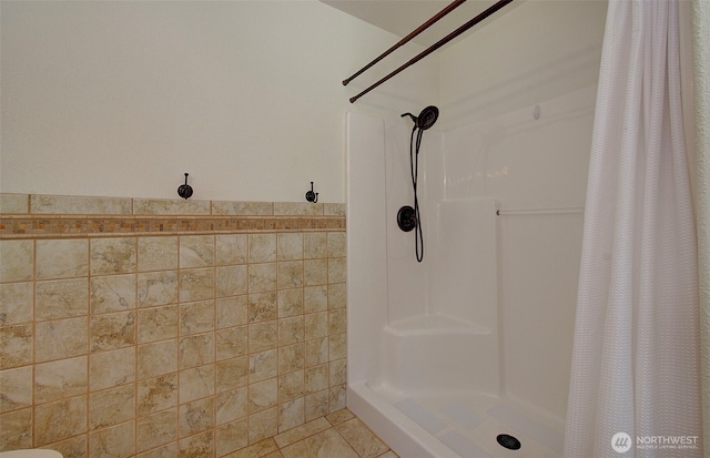 bathroom featuring tile walls, tile patterned flooring, and a shower stall