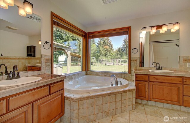 full bath with a sink, a bath, visible vents, and tile patterned floors