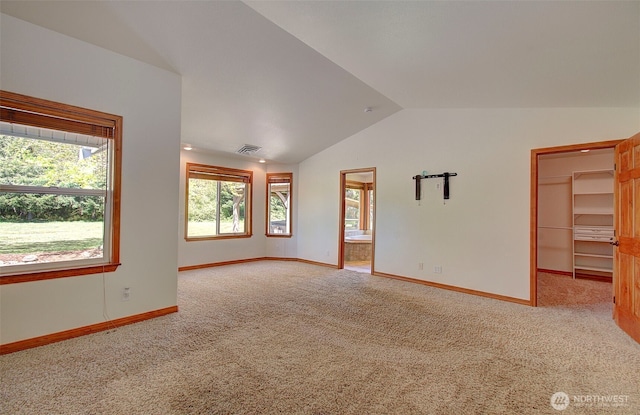 interior space featuring baseboards, visible vents, carpet floors, and vaulted ceiling