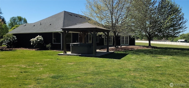 view of yard featuring a hot tub, a gazebo, fence, and french doors