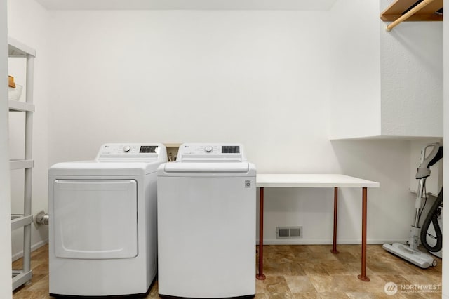 clothes washing area with washing machine and dryer and baseboards
