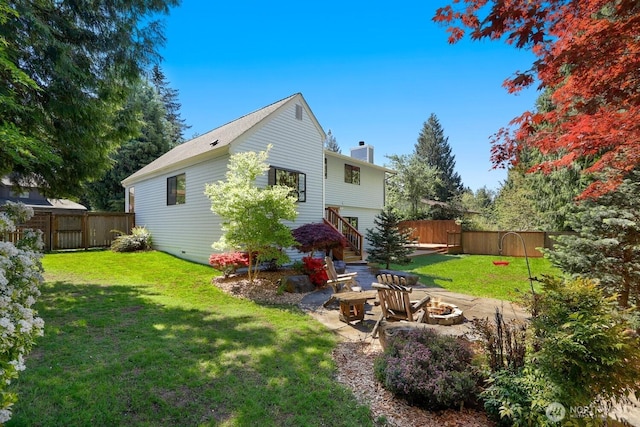 back of property featuring an outdoor fire pit and a chimney