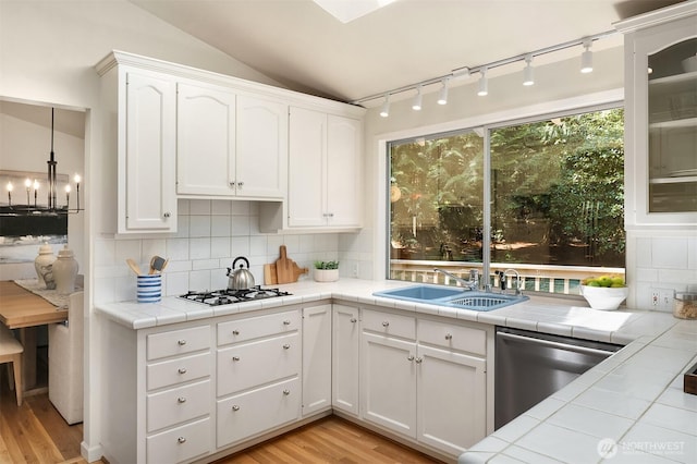 12802 NE 26th Pl, Bellevue, WA 98005 - kitchen featuring stainless steel dishwasher, a sink, backsplash, rail lighting, and vaulted ceiling