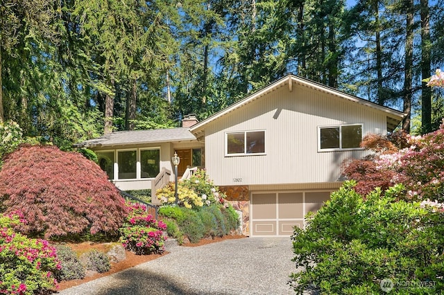 12802 NE 26th Pl, Bellevue, WA 98005 - tri-level home featuring stone siding, asphalt driveway, a chimney, and an attached garage