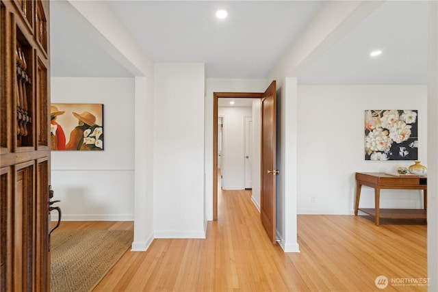 hall featuring light wood-style floors, recessed lighting, and baseboards