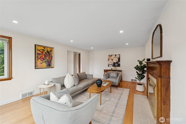 living area with light wood-style flooring, recessed lighting, and baseboards
