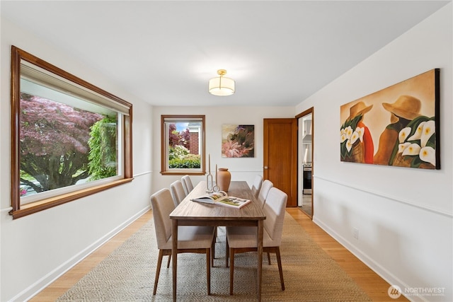 dining area with light wood finished floors and baseboards