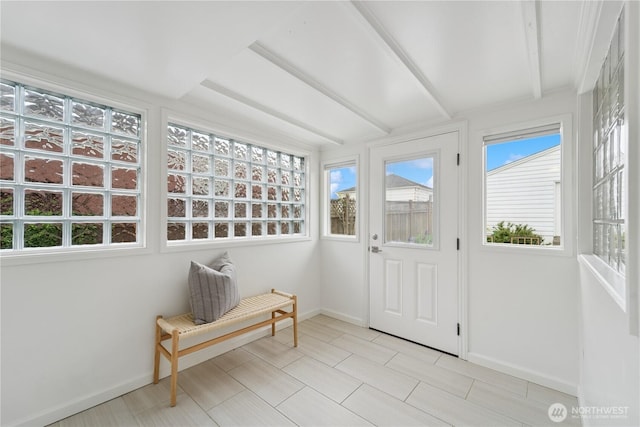 sunroom / solarium featuring beamed ceiling