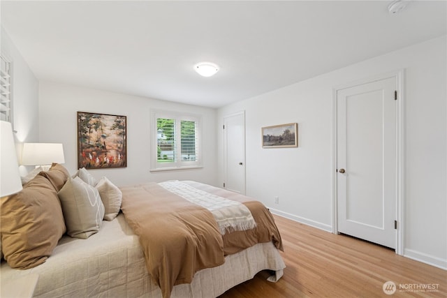 bedroom with light wood-style flooring and baseboards