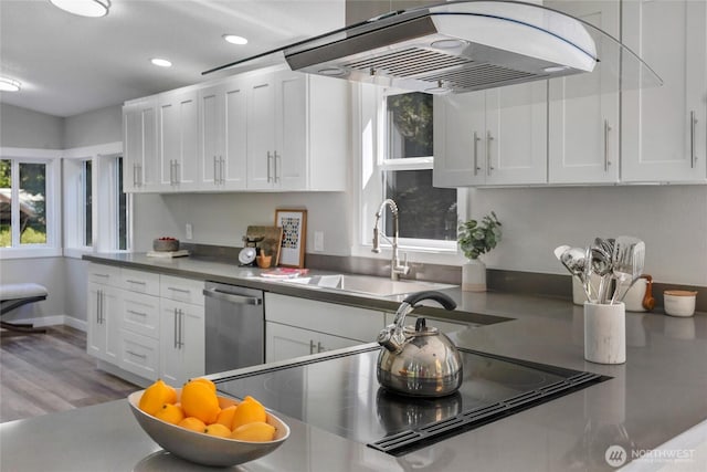kitchen with stainless steel dishwasher, range hood, white cabinetry, a sink, and recessed lighting