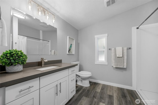 full bath with baseboards, visible vents, curtained shower, vanity, and wood finished floors