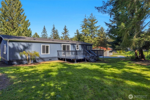 rear view of property featuring a lawn, a wooden deck, and crawl space
