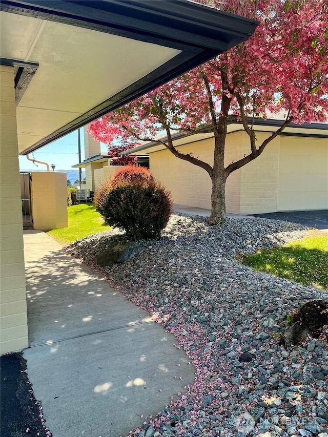 view of side of property with central air condition unit and concrete block siding