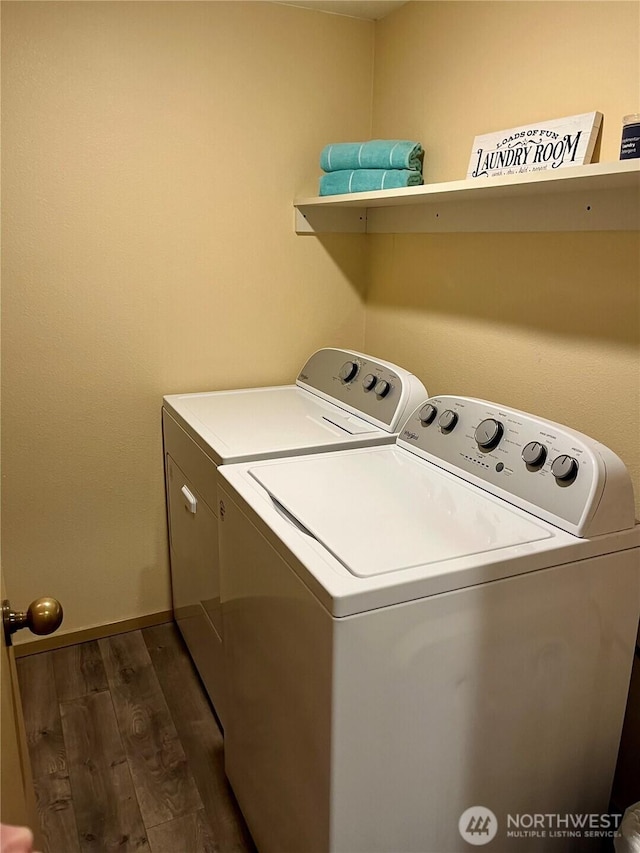clothes washing area featuring laundry area, baseboards, separate washer and dryer, and dark wood finished floors