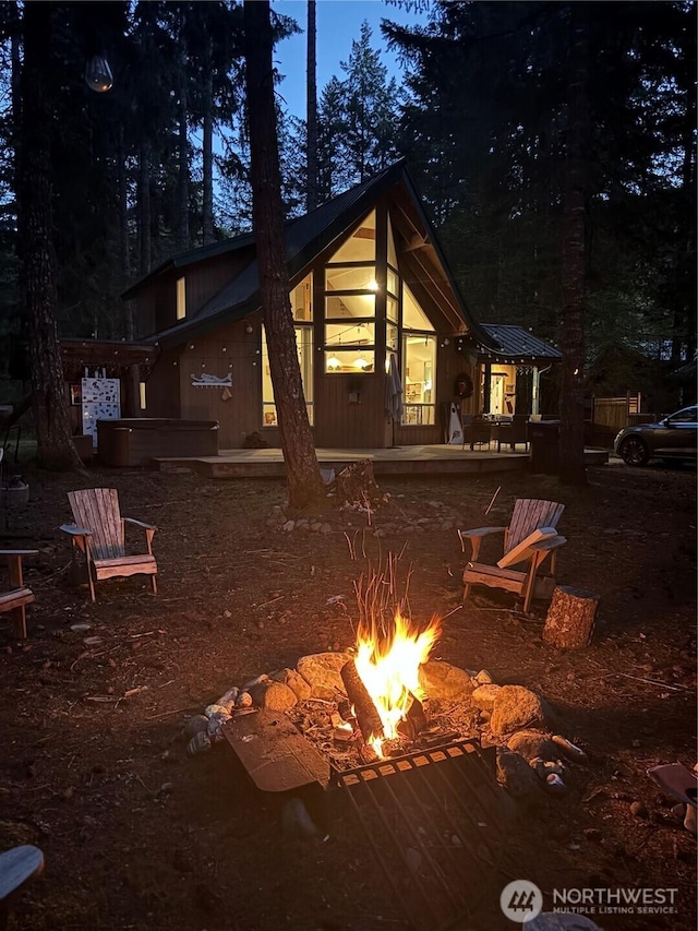 back of house with a fire pit
