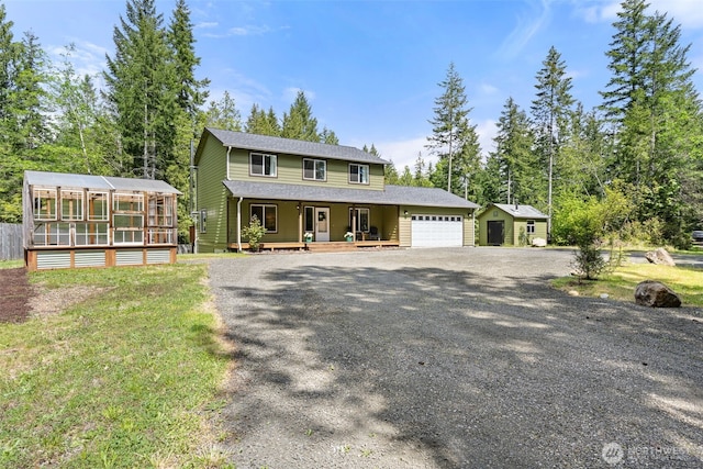 401 E Sunset Ridge Rd, Union, WA 98592 - view of front facade featuring a garage, covered porch, gravel driveway, and a sunroom