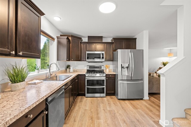 401 E Sunset Ridge Rd, Union, WA 98592 - kitchen with stainless steel appliances, a sink, light wood finished floors, dark brown cabinets, and light countertops