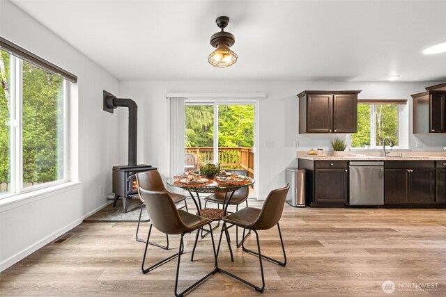 401 E Sunset Ridge Rd, Union, WA 98592 - dining space featuring plenty of natural light, a wood stove, light wood-style floors, and baseboards